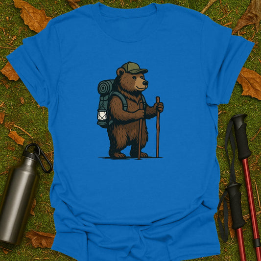 Blue t-shirt with a bear graphic holding a lantern and walking stick on grass.