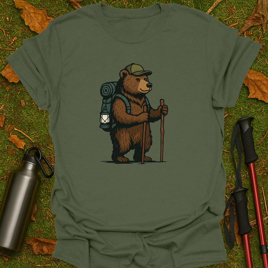 Green t-shirt with a bear graphic holding a lantern and walking stick on grass.