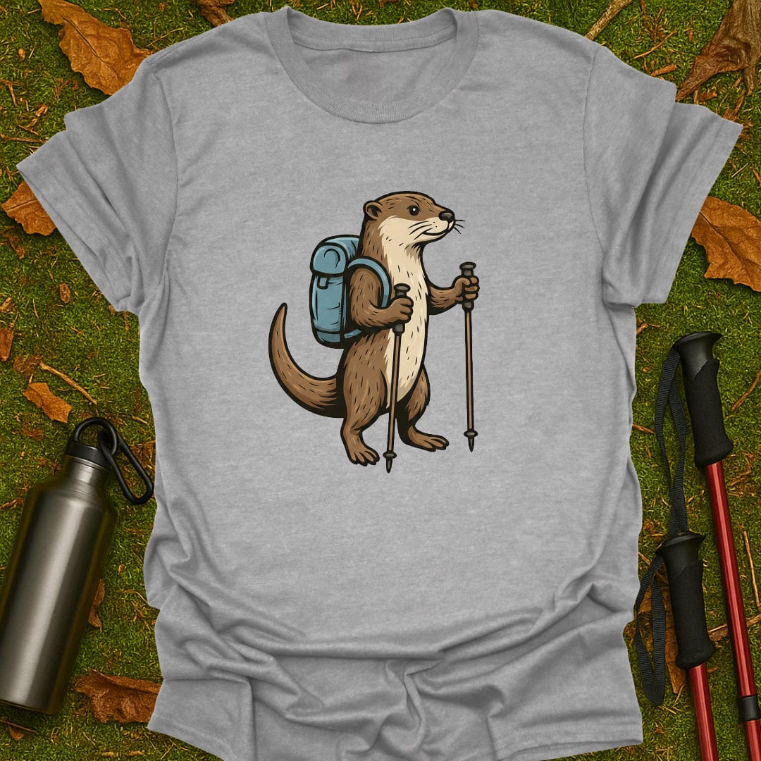 Gray t-shirt with an otter wearing a backpack and holding hiking poles on a grassy background.